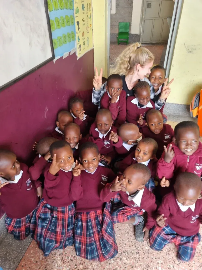 Strahlende Schulkinder posieren fröhlich mit den Supernurses – Bildung und Gesundheit Hand in Hand.