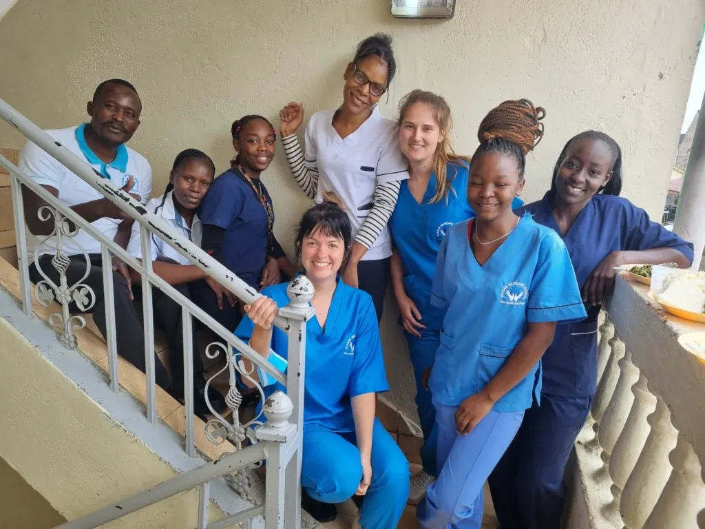 Supernurses und einheimische Ärzte stehen gemeinsam vor einer Klinik in Afrika – vereint für eine bessere medizinische Versorgung.