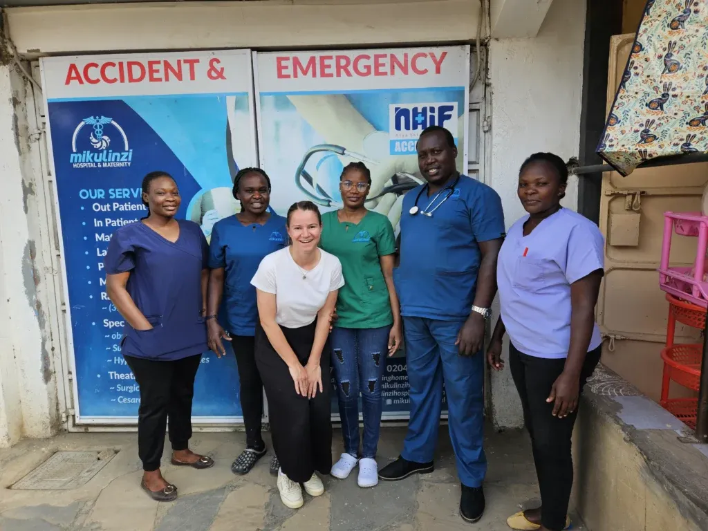 Eine Supernurse posiert gemeinsam mit fünf Ärzten und Krankenschwestern – ein starkes Team für eine bessere medizinische Versorgung.