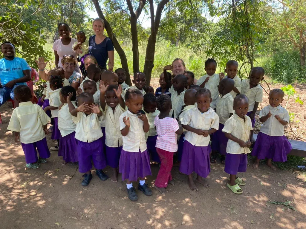 Strahlendes Gruppenfoto mit Supernurses und Kindern – ein Moment voller Freude und Zusammenhalt.