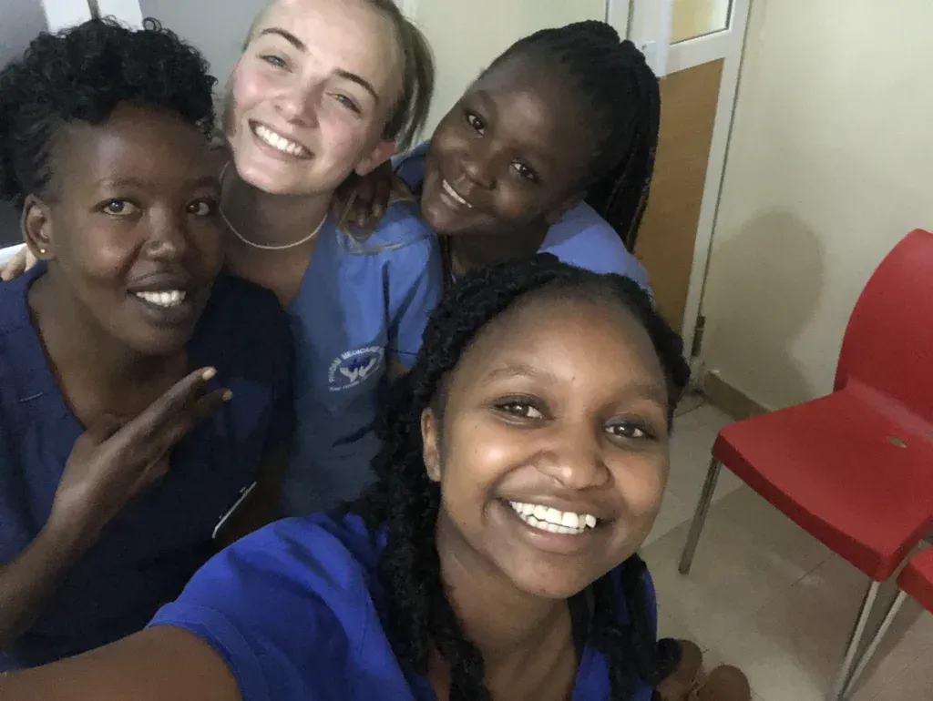 Eine Supernurse macht ein fröhliches Selfie mit drei einheimischen Krankenschwestern – ein starkes Team für die Gesundheit.